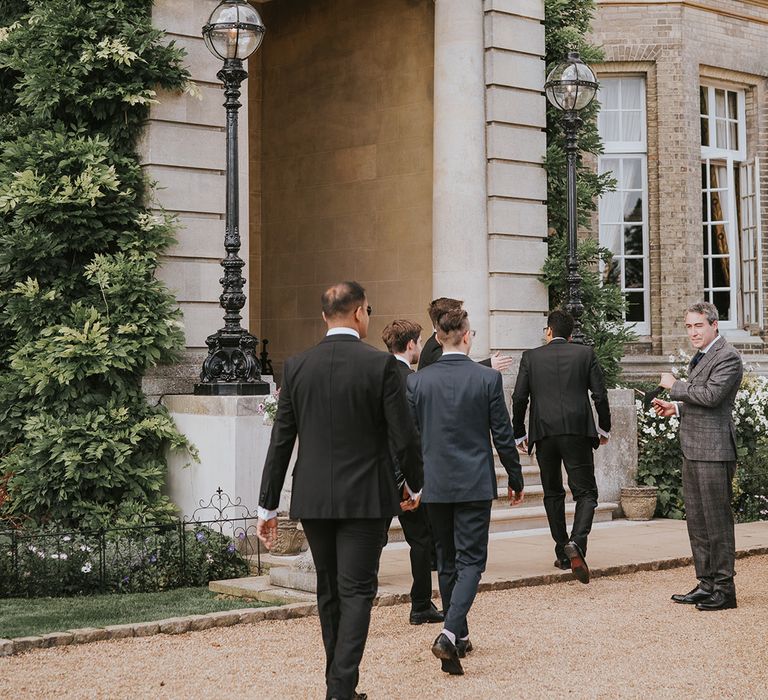 Wedding guests filter in to take their seats at Hedsor House