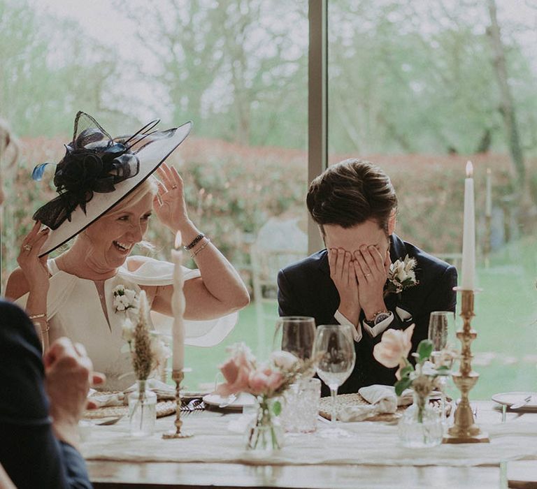 Bride and groom react to the speeches at their wedding reception 