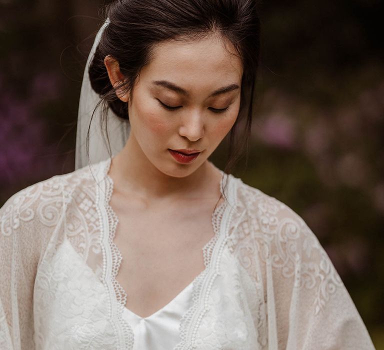 East Asian bride in a lace kimono-style wedding dress tied with a yellow ribbon with natural makeup 