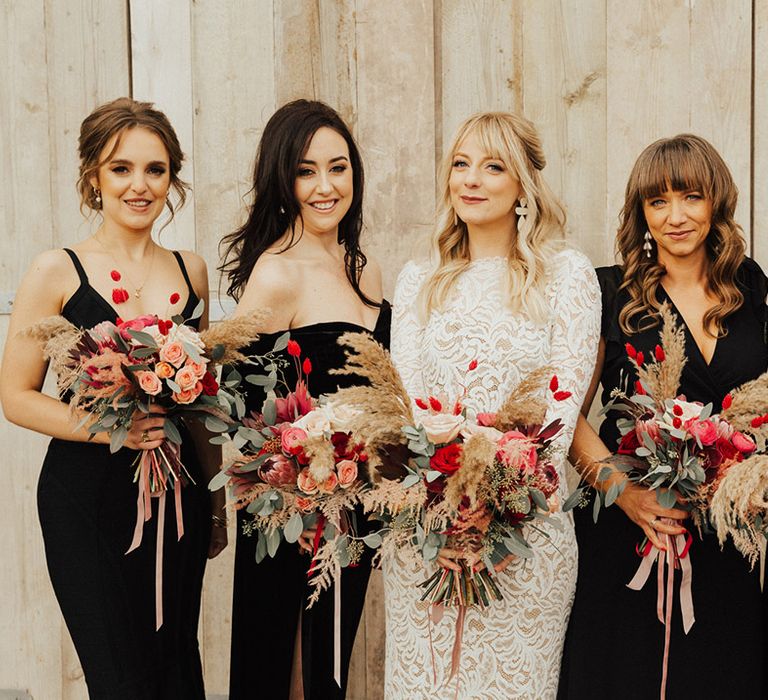 Bride in a long sleeve lace wedding dress with her I Do Crew in black dresses for a gender neutral wedding 