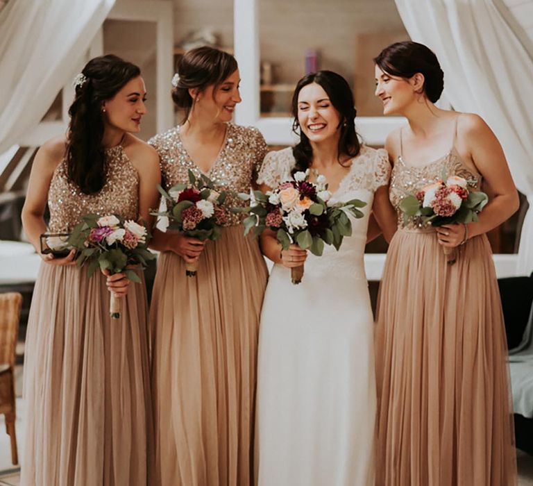 Classic gold bridesmaid dresses with embellishments with the bride on her wedding day 