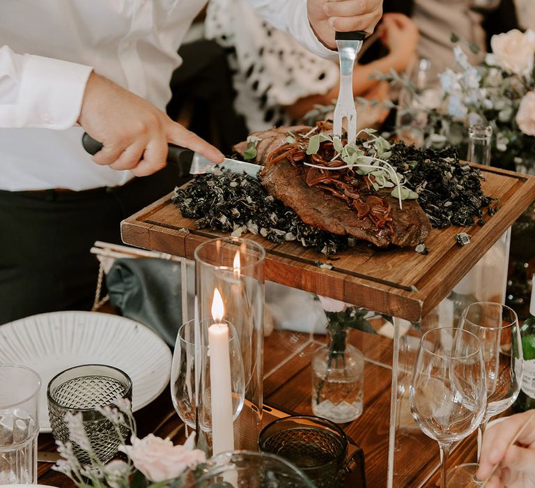 Chefs walk around the tables and carve the meat in front of the wedding guests 