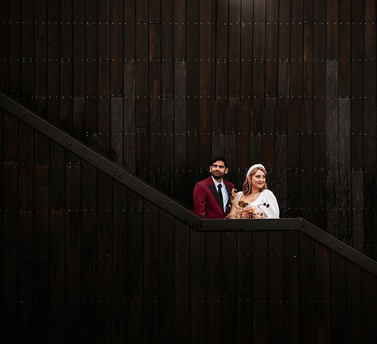 Bride and groom at the cool Crumplebury wedding venue with black cladding 