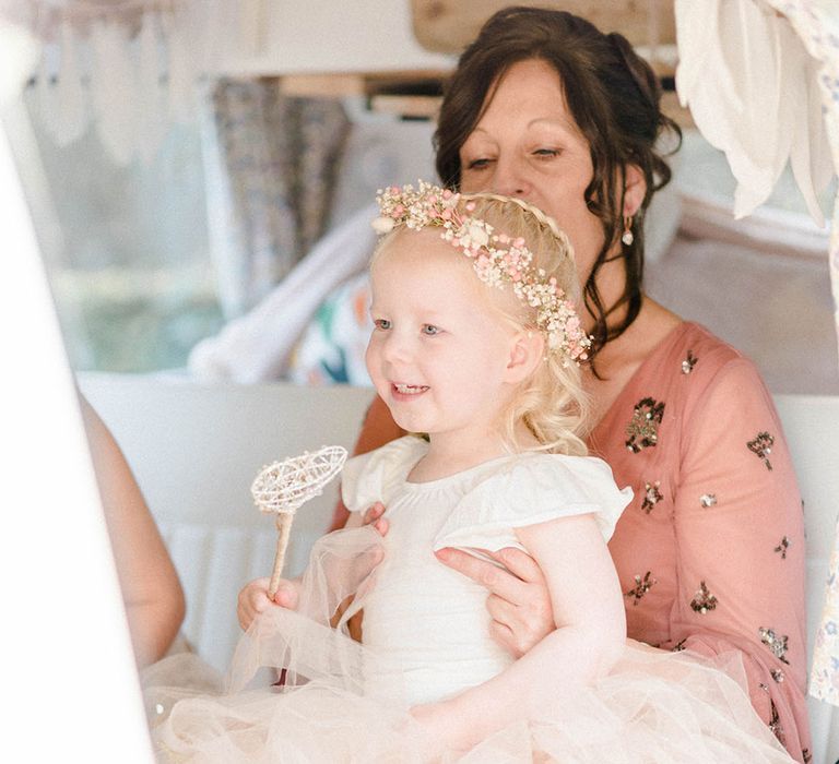 Flower girl wears pastel peach tutu and baby's-breath flower crown