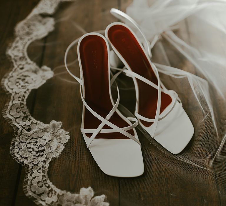 Embroidered lace edge veil with white square toe heels with thin straps for the bride 