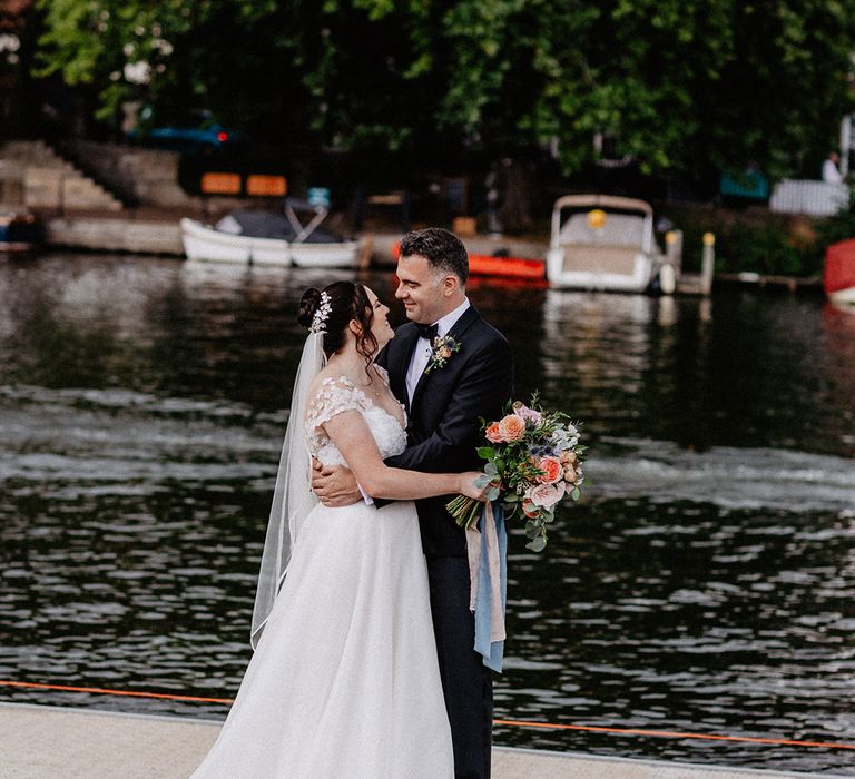 The bride and groom stare into each other's eyes and smile at each other for their traditional wedding 