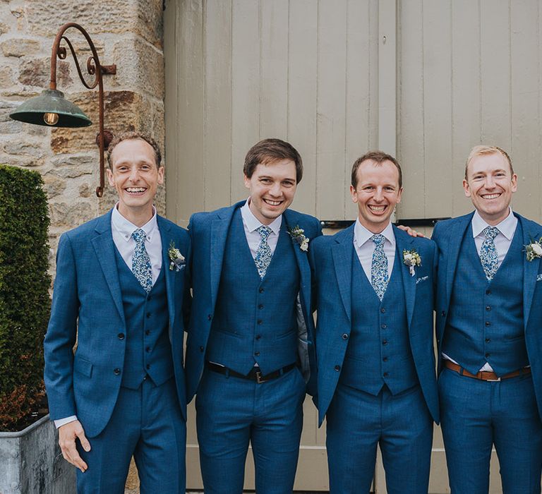 Groomsmen in Navy blue three-piece suits with floral ties 