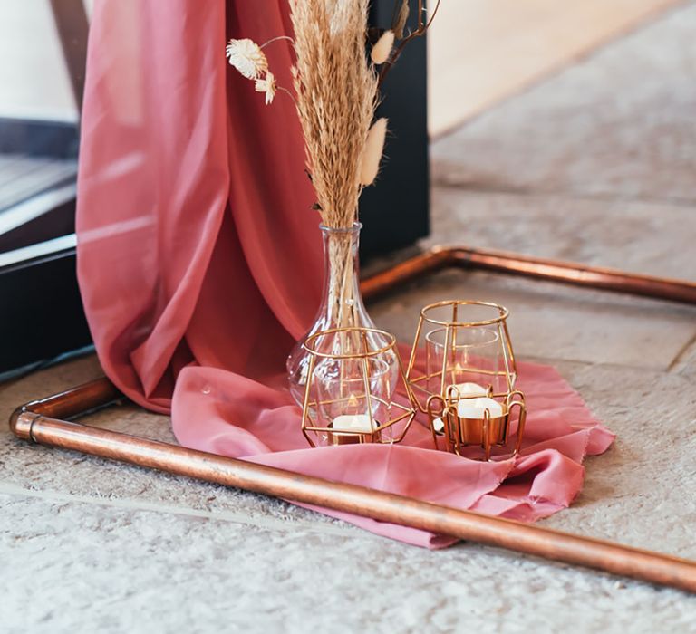 Pink wedding drapery with pampas grass and bunny grass with glass vase and gold candleholders 