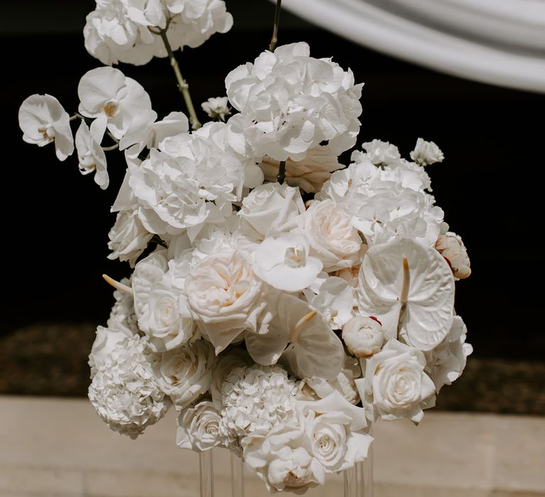 White orchids, roses, hydrangeas, anthuriums and more make up these wedding flower arrangements 