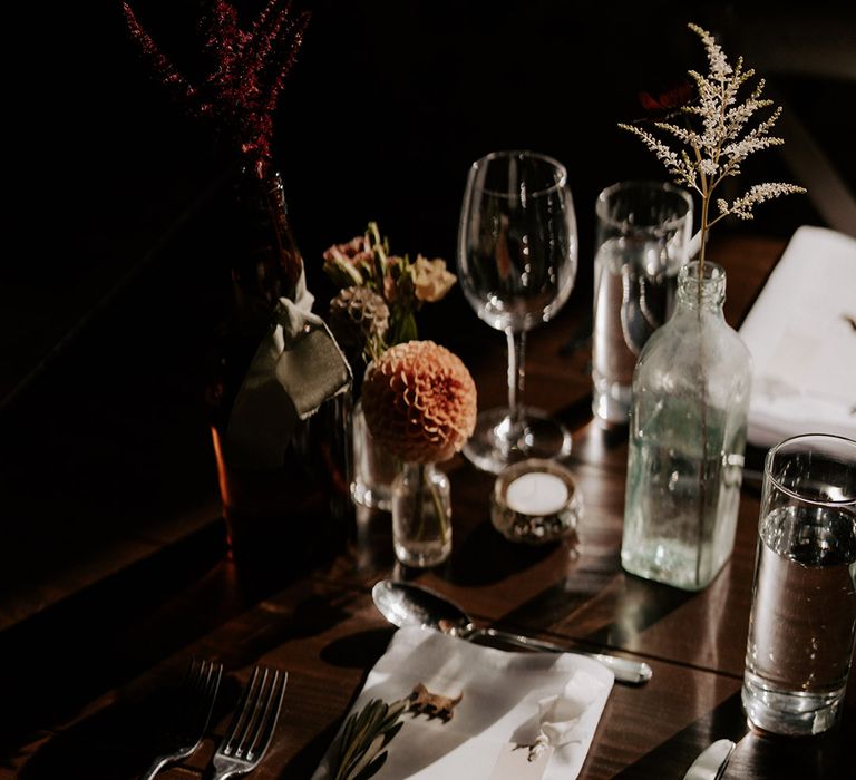 Minimal place setting with white napkin and white wedding menu with silver cutlery and place name 