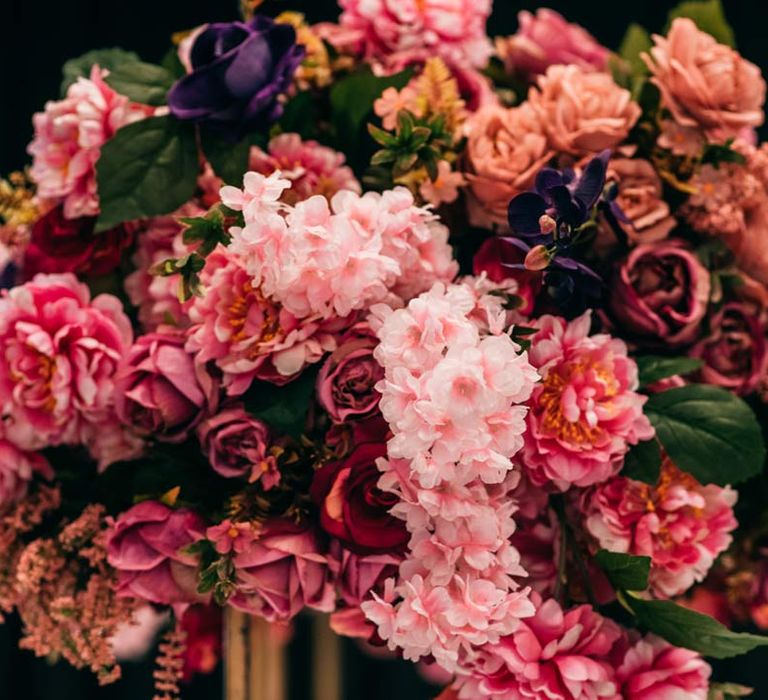 Vibrant pink bridal bouquet with pink azaleas, garden roses, rhododendrons and foliage 