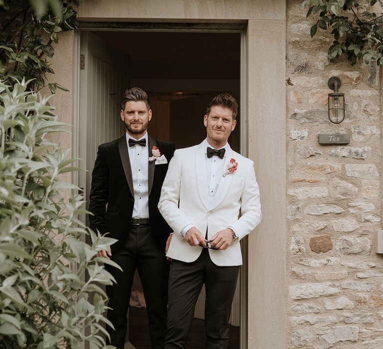 Groom in white tuxedo with best man in classic black tie for the luxe contemporary style wedding 