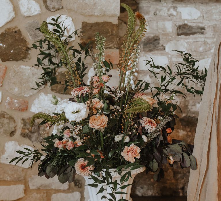 Orange and white wedding flowers in white flower vase 