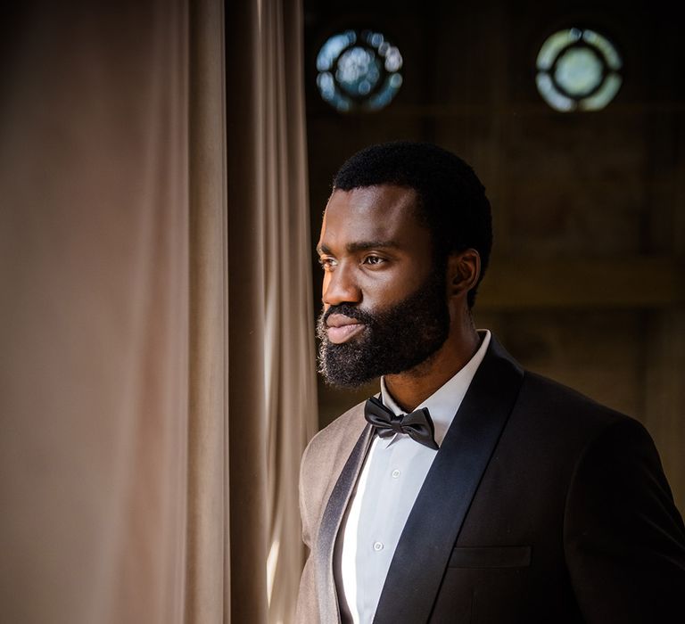 Groom wearing black tuxedo with black tie 