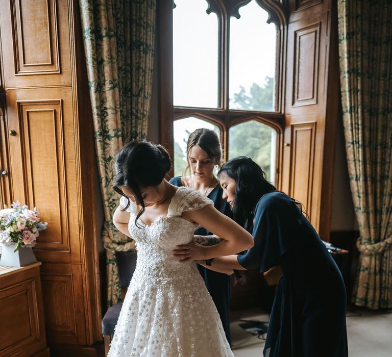 Bride in Sassi Holford wedding dress with her bridesmaids getting ready for the wedding 