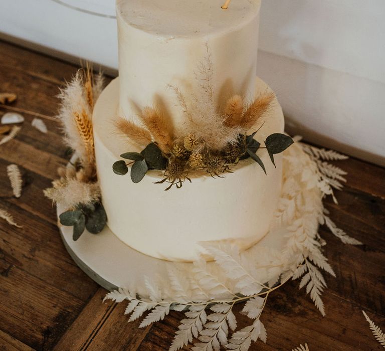 White frosted wedding cake with bunting cake topper for bohemian wedding 