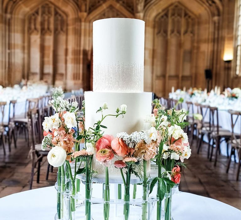 Minimalist traditional white wedding cake decorated with flower stems 