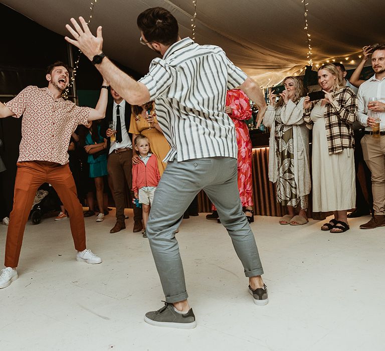 LGBTQIA+ wedding with two grooms in striped shirts for choreographed first dance 