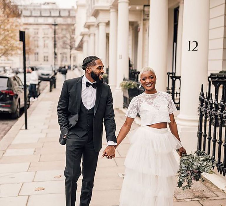 Bride and Groom walking through London in black suit and Bridal two piece set by David Dean Photographic