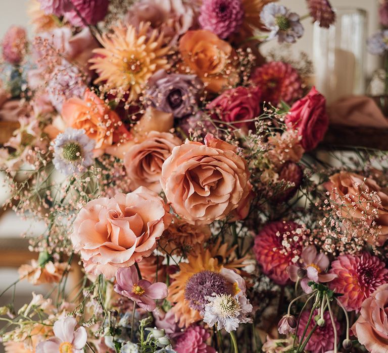 Pink, orange, peach and blue wedding flower arrangements with roses, dahlias and more 