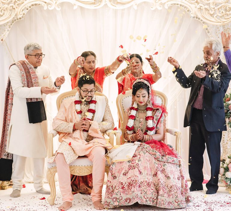 Bride and grooms family throwing confetti over the couple 