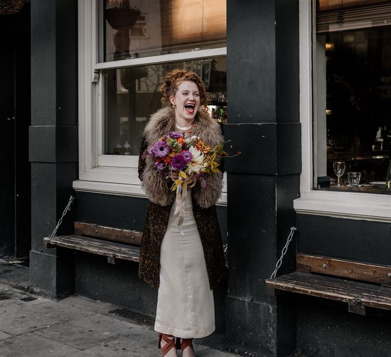 Bride in printed coat with bright bouquet