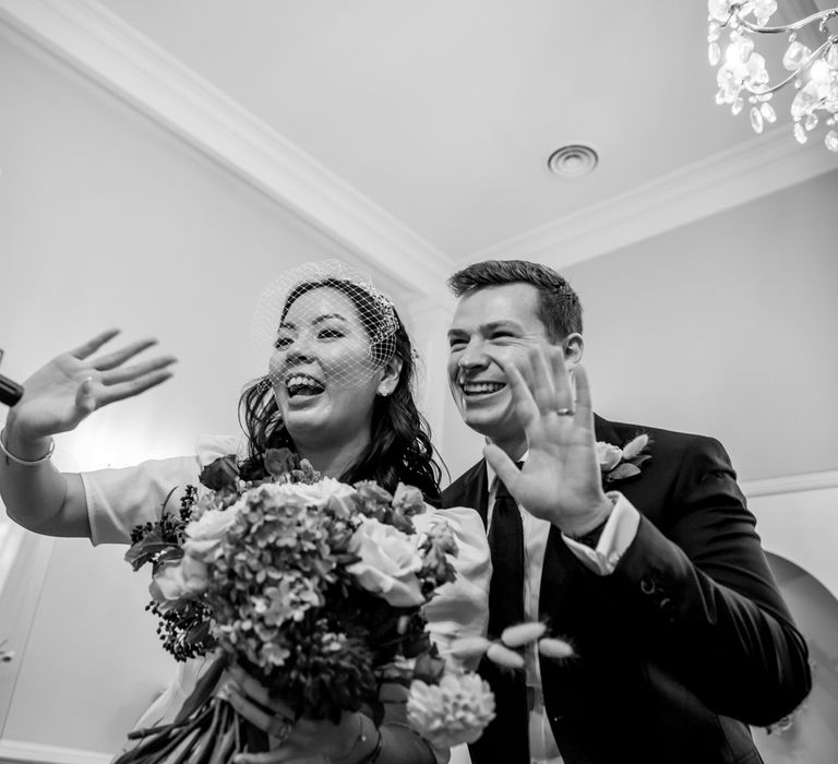 Bride and groom waving to their virtual wedding guests 