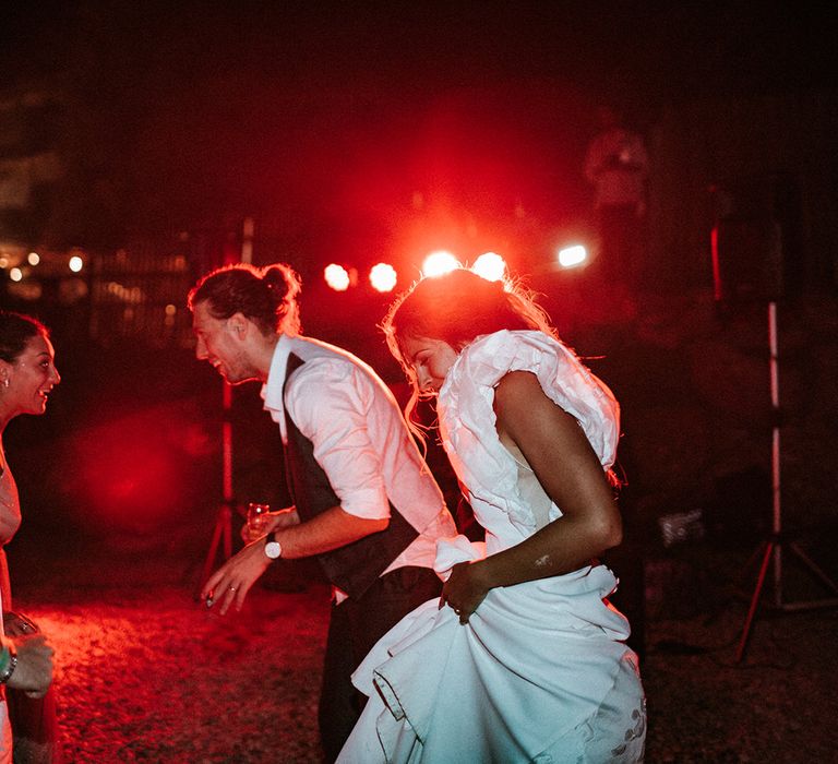 Bride and groom dancing on the beach with bride in a ruffle sleeve wedding dress