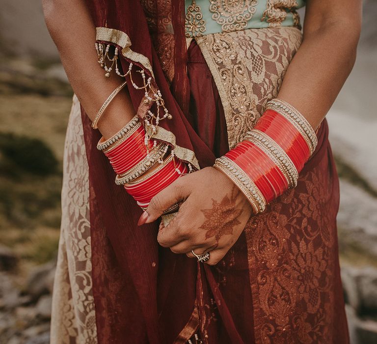 The bride wore beautiful red bangals with her maroon and gold wedding dress