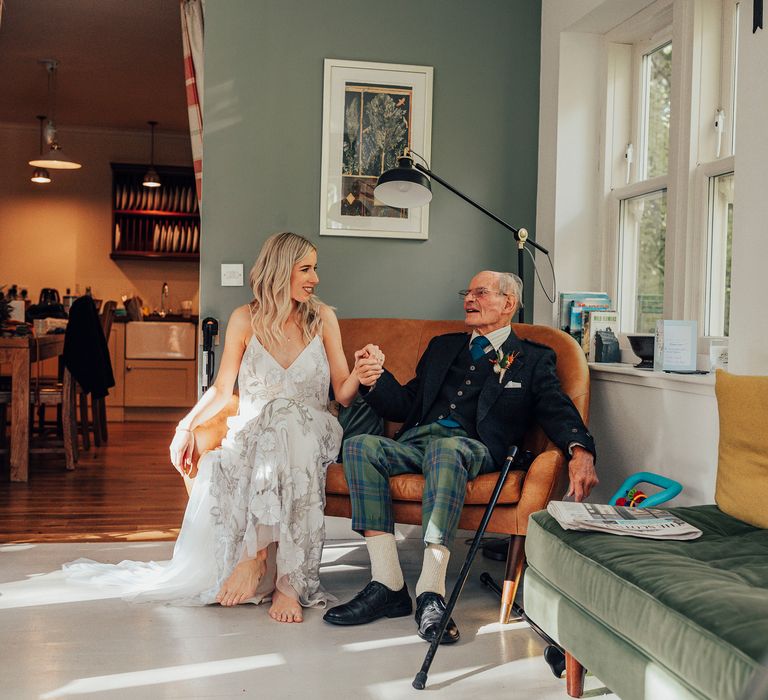 Bride sits with wedding guest who is wearing Tartan trousers