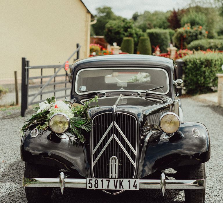 A black vintage wedding car at a French wedding.