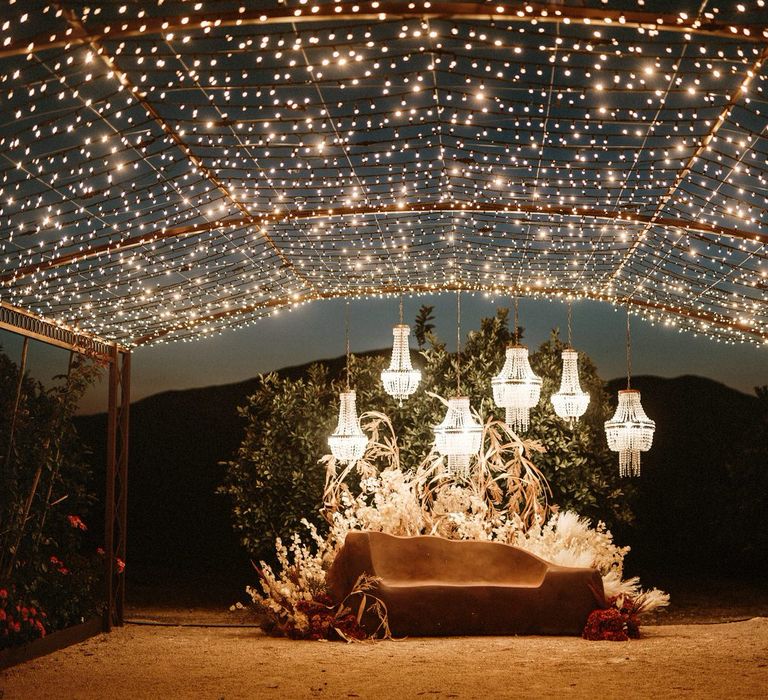 Outdoor chandelier light installation and fairy light canopy boho wedding flowers and decor 