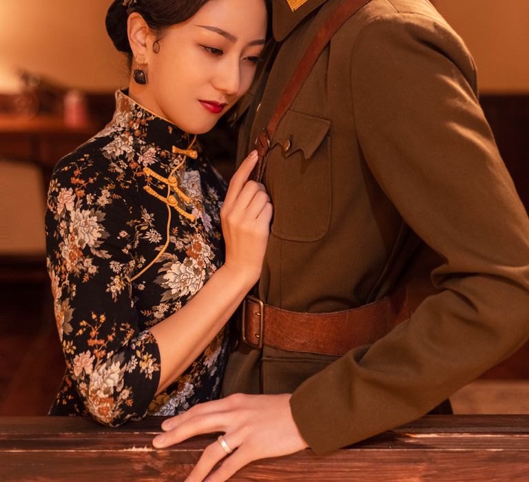 Bride-to-be leans head against partner whilst wearing traditional 1920s Western era Chinese attire