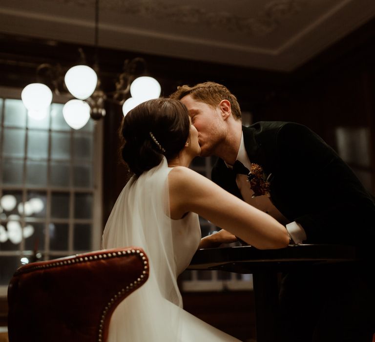 Bride and groom kissing sat down