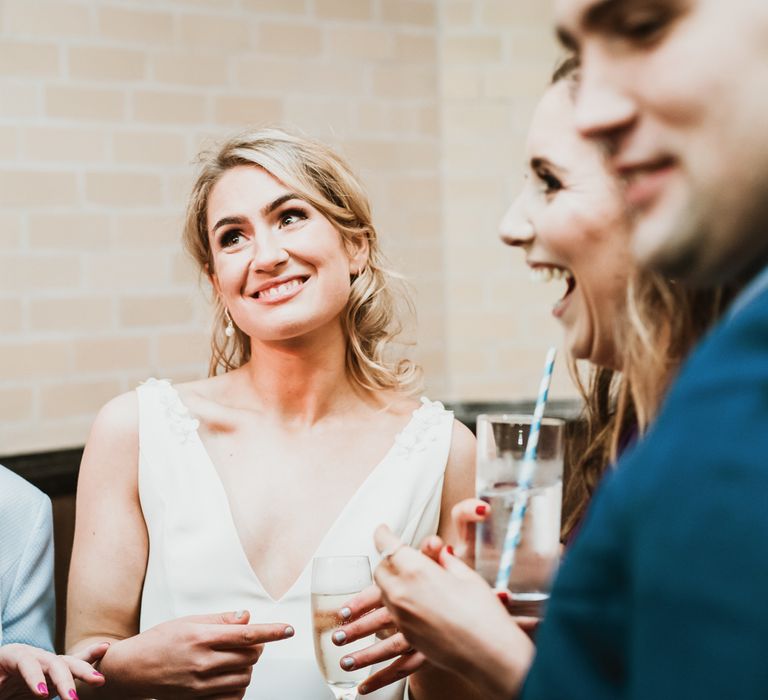 Bride laughs with wedding guests on the day of her wedding