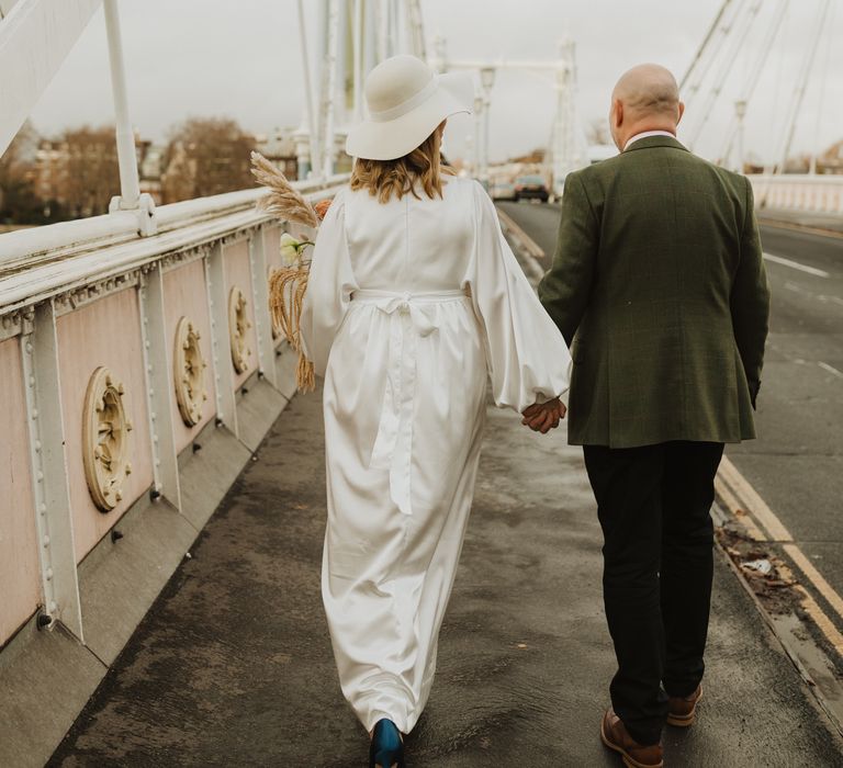 Bride & groom walk away from camera on the bride in London