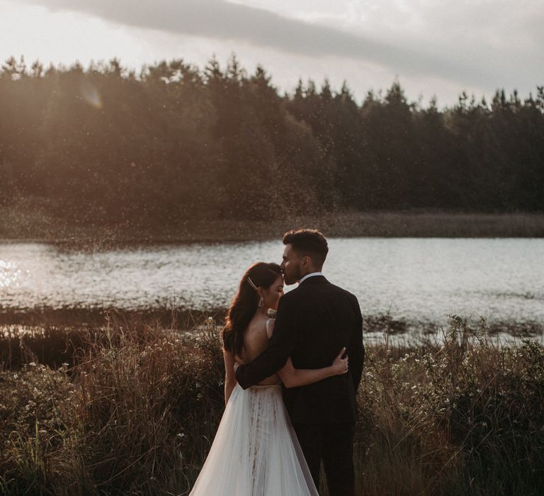 Bride and groom looking out at a lake