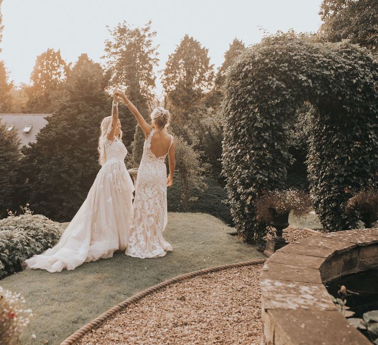 Two brides dance int he grounds of Crab & Lobster at sundown.