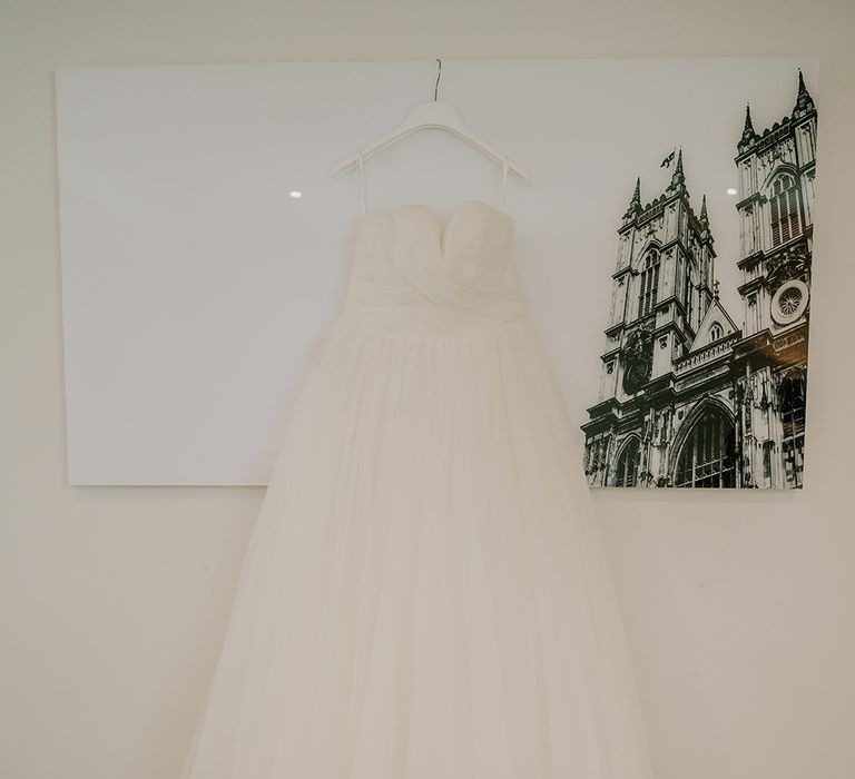 Bridal dress hangs on the morning of wedding day