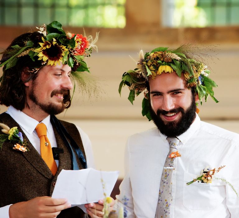 Grooms smile on their wedding day as they read speech during reception