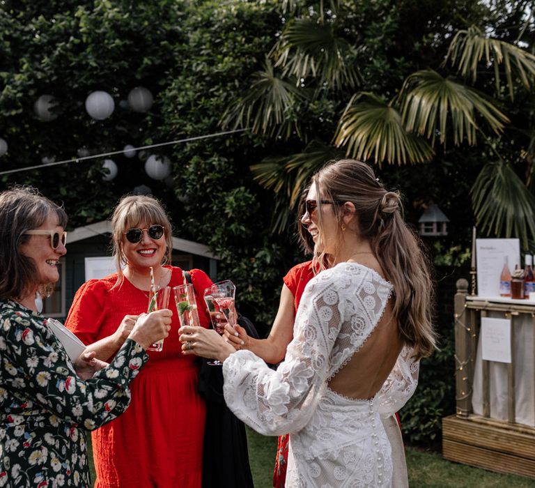 Bride shares a toast with wedding guests at garden wedding