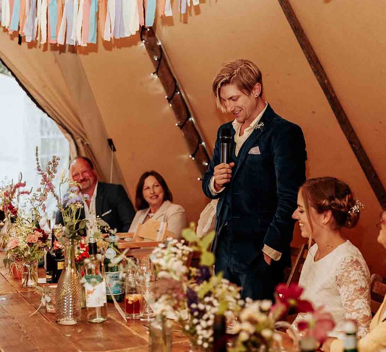 Groom makes wedding speeches in tipi 