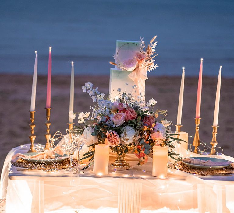 relaxed low table, cushions and fairy lights on the beach 