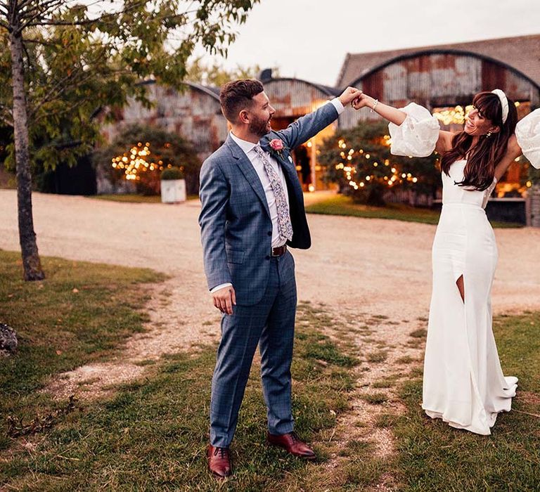 Bride & groom celebrate outdoors on their wedding day after Cotswolds wedding ceremony