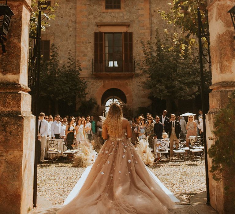 Bride walks into wedding ceremony wearing beautiful star gown