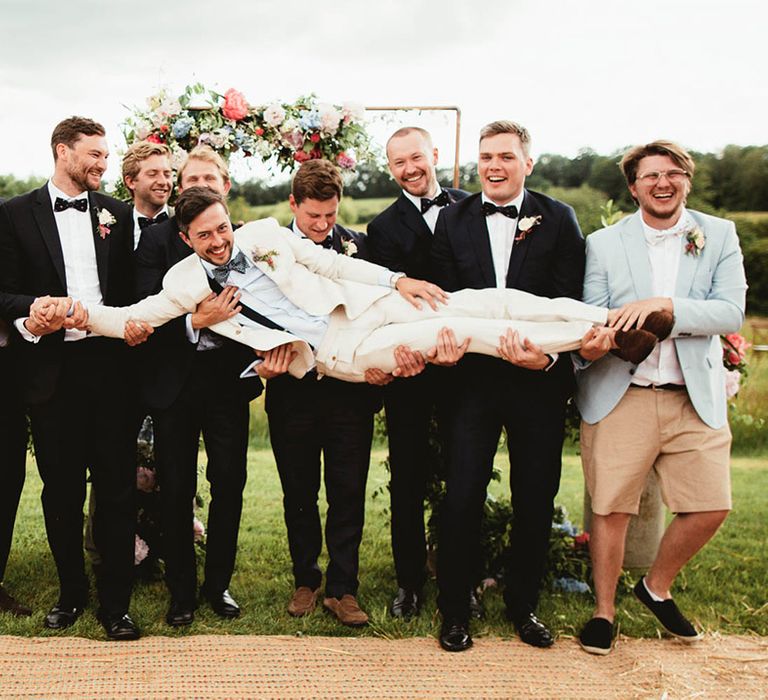 Groom is picked up by his groomsmen on his wedding day