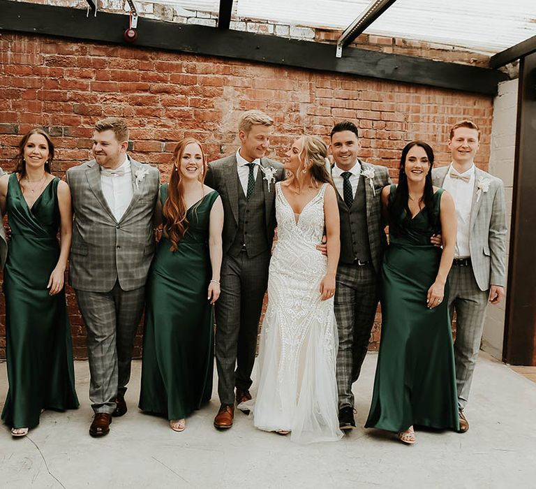 Bridesmaid in emerald green dresses with groomsmen in check suits