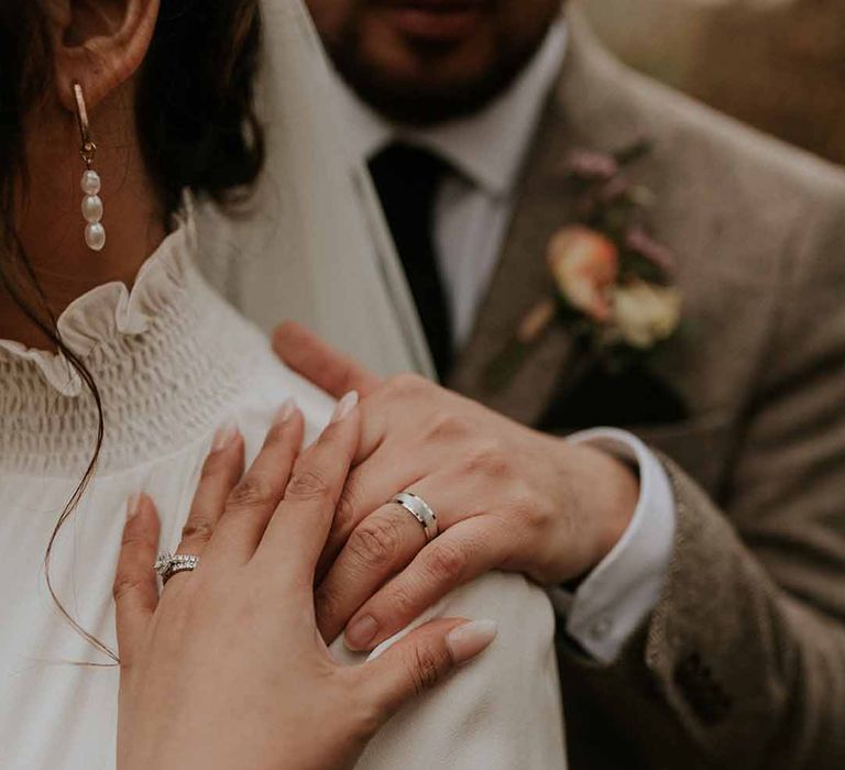 Wedding rings and neutral nails with 3 pearl-beaded necklace