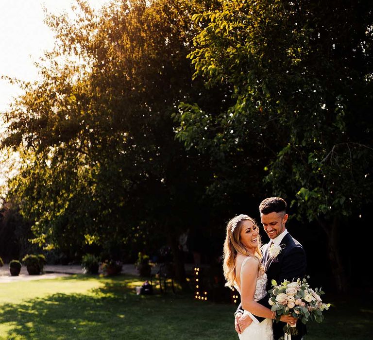 Groom places his hands on the bride's derrière wearing lace wedding dress