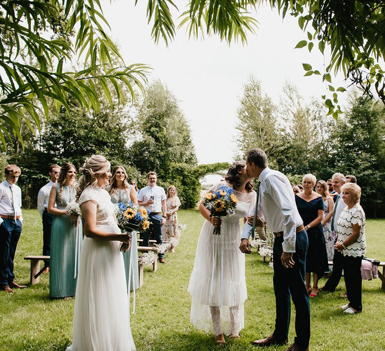 Bride kisses her father as he leaves her at the altar for outdoor wedding 